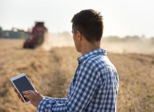 Stock photo: farmer with iPad and combine