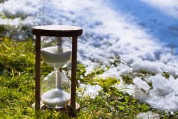 hourglass by snow and grass